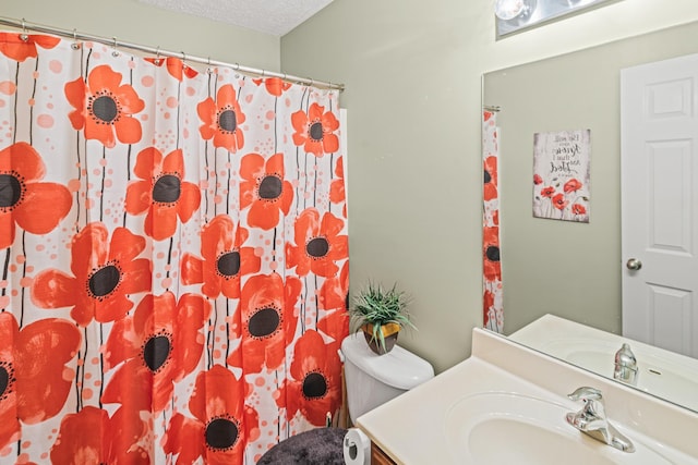 bathroom featuring vanity, toilet, and a textured ceiling