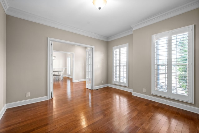 spare room with baseboards, ornamental molding, and hardwood / wood-style floors