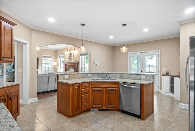 kitchen featuring stainless steel appliances, sink, pendant lighting, and light stone counters