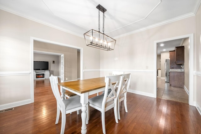 dining space featuring crown molding and dark hardwood / wood-style flooring