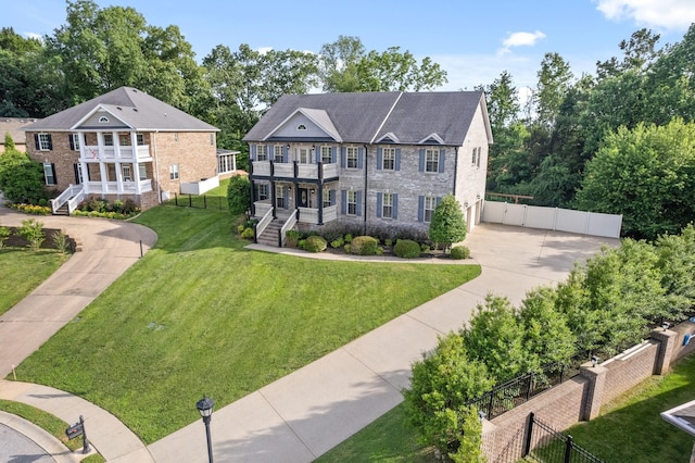 view of front of house featuring a balcony and a front yard