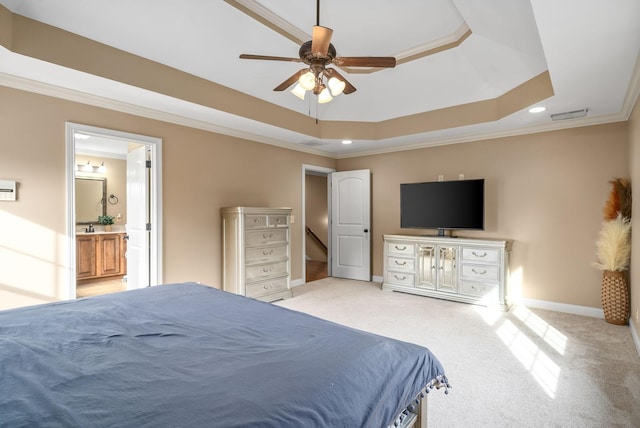 bedroom featuring connected bathroom, light carpet, baseboards, ornamental molding, and a raised ceiling