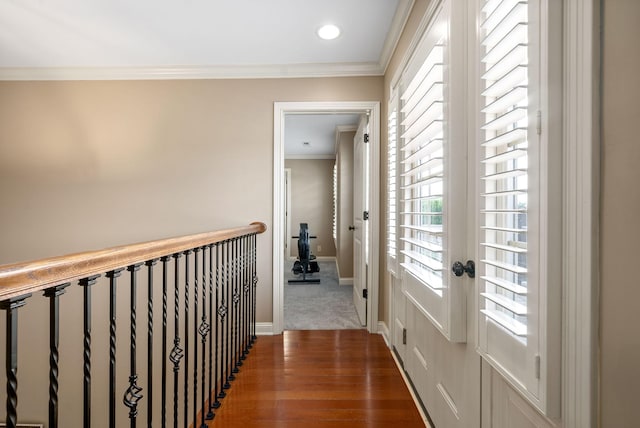 hallway featuring wood-type flooring and ornamental molding