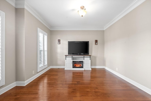 unfurnished living room with hardwood / wood-style flooring and crown molding