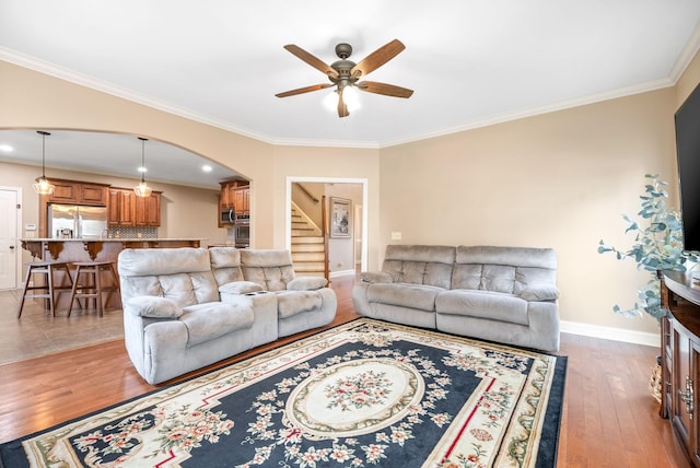 living room featuring dark hardwood / wood-style flooring, crown molding, and ceiling fan