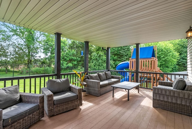 wooden terrace with an outdoor hangout area, a playground, and fence