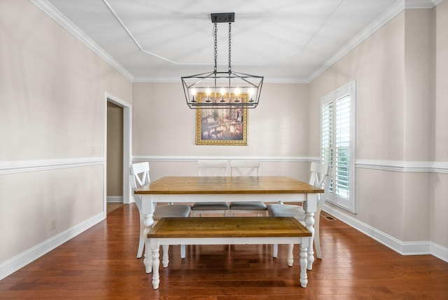 dining room featuring hardwood / wood-style flooring, crown molding, and a chandelier