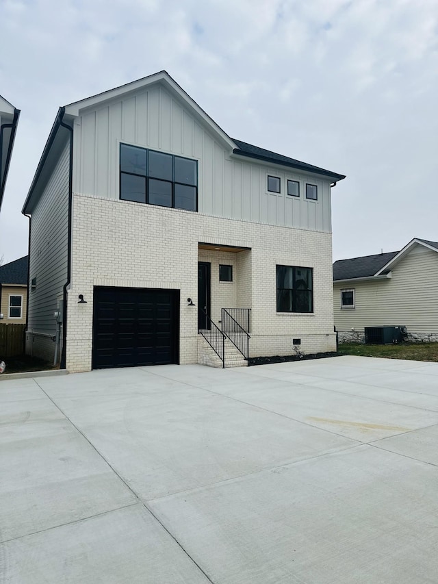 view of front of house featuring a garage and central AC