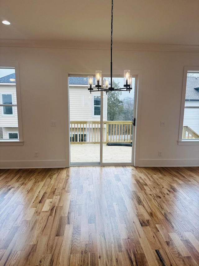 unfurnished dining area featuring ornamental molding, a wealth of natural light, and a chandelier