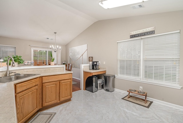 kitchen with vaulted ceiling, sink, pendant lighting, and a chandelier