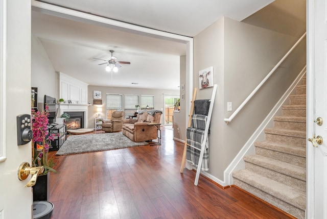 living room with dark wood-type flooring and ceiling fan