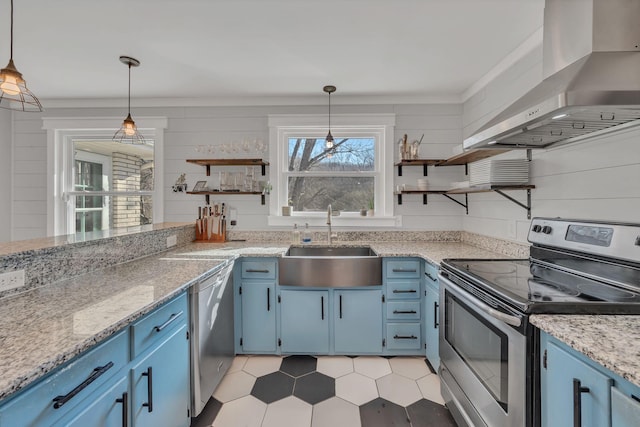 kitchen featuring decorative light fixtures, blue cabinets, range hood, sink, and stainless steel appliances