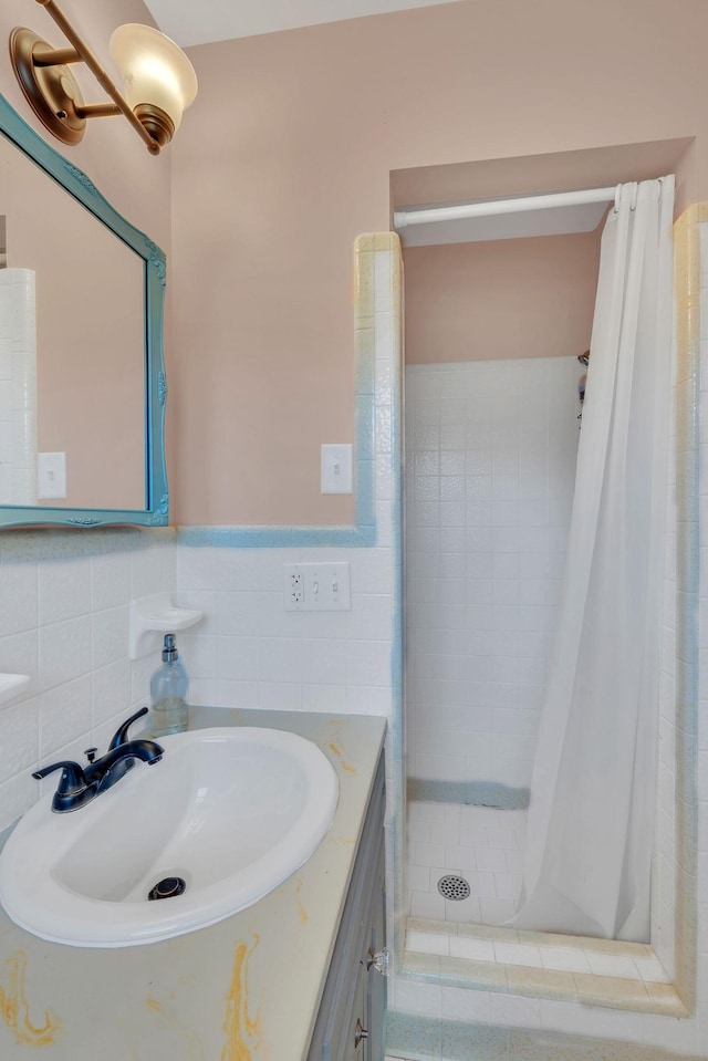 bathroom with vanity, a shower with shower curtain, and tile walls