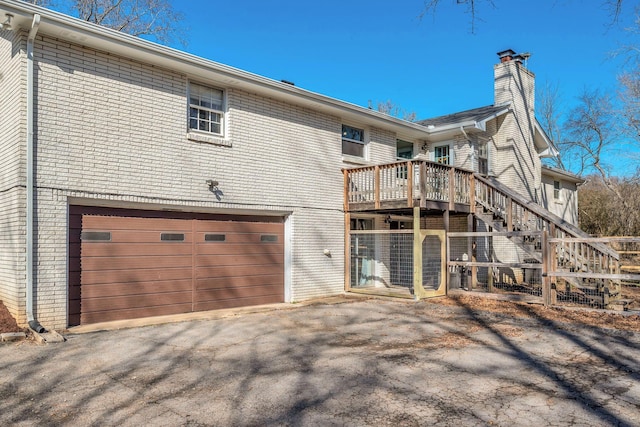 back of property featuring a garage and a wooden deck