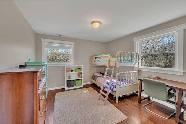 bedroom with multiple windows and hardwood / wood-style floors