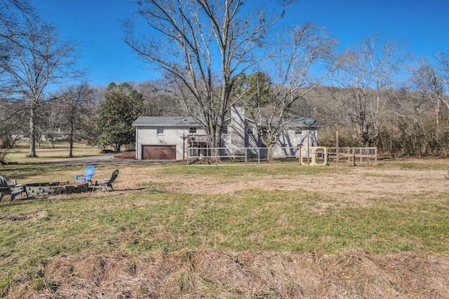 view of yard with a garage and a fire pit