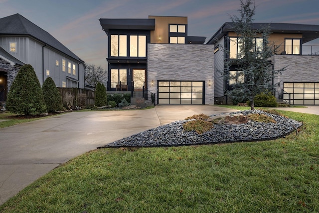 view of front of house featuring a garage and a lawn