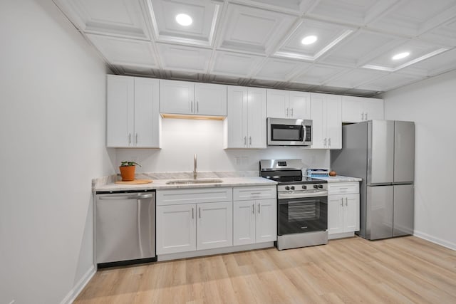 kitchen with white cabinetry, appliances with stainless steel finishes, sink, and light wood-type flooring