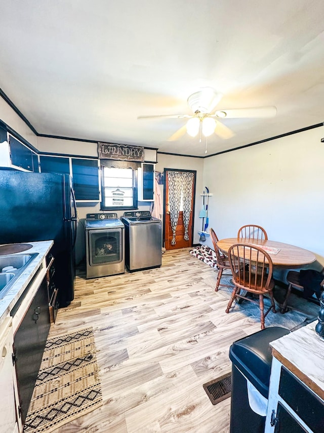 kitchen with black refrigerator, separate washer and dryer, ceiling fan, white dishwasher, and light hardwood / wood-style floors