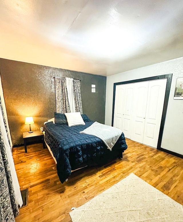 bedroom with hardwood / wood-style floors and a closet