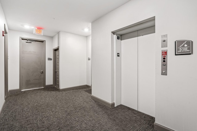 corridor with dark carpet and elevator