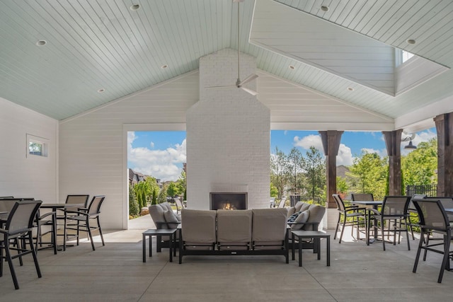 view of patio with an outdoor living space with a fireplace