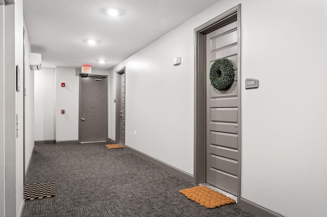 hallway featuring dark carpet and a wall unit AC