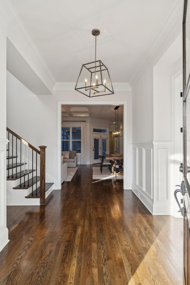 foyer featuring crown molding, hardwood / wood-style floors, and a chandelier