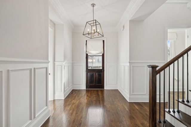 entryway featuring dark hardwood / wood-style flooring, a notable chandelier, and ornamental molding