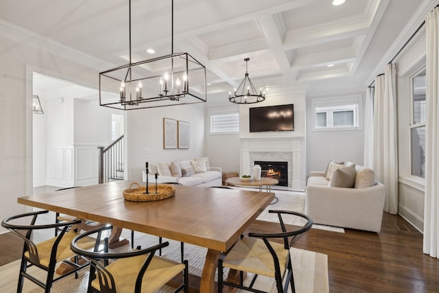 dining space featuring beamed ceiling, ornamental molding, coffered ceiling, and dark hardwood / wood-style flooring