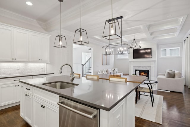 kitchen featuring white cabinetry, stainless steel dishwasher, sink, and a kitchen island with sink