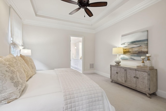 carpeted bedroom with crown molding, connected bathroom, and a tray ceiling