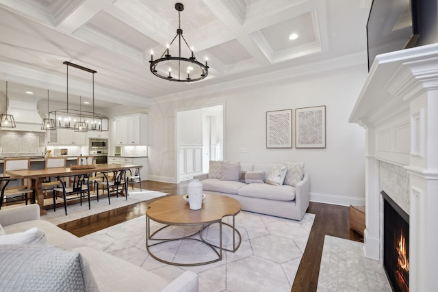 living room featuring coffered ceiling, beam ceiling, a chandelier, and light hardwood / wood-style flooring