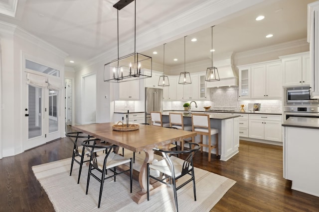 dining area with dark hardwood / wood-style flooring, sink, and ornamental molding