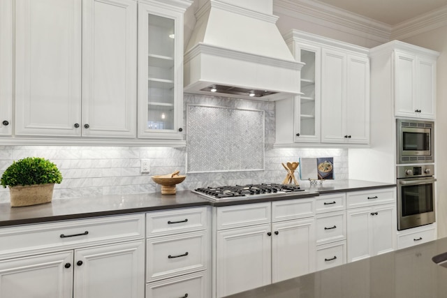 kitchen with premium range hood, white cabinetry, backsplash, ornamental molding, and stainless steel appliances