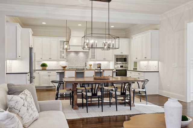 kitchen featuring dark hardwood / wood-style floors, pendant lighting, white cabinetry, decorative backsplash, and stainless steel appliances