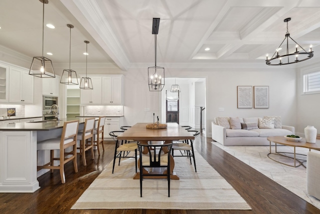 dining room with beamed ceiling, ornamental molding, dark hardwood / wood-style floors, and sink