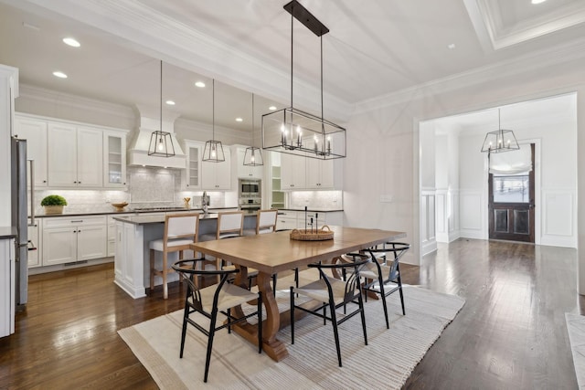 dining space with ornamental molding, an inviting chandelier, and dark hardwood / wood-style flooring