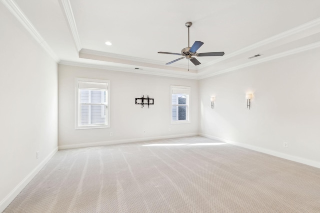 carpeted empty room with crown molding, a raised ceiling, and ceiling fan