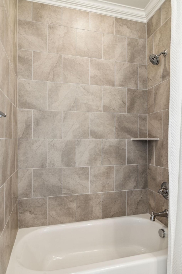 bathroom with ornamental molding and shower / bath combo