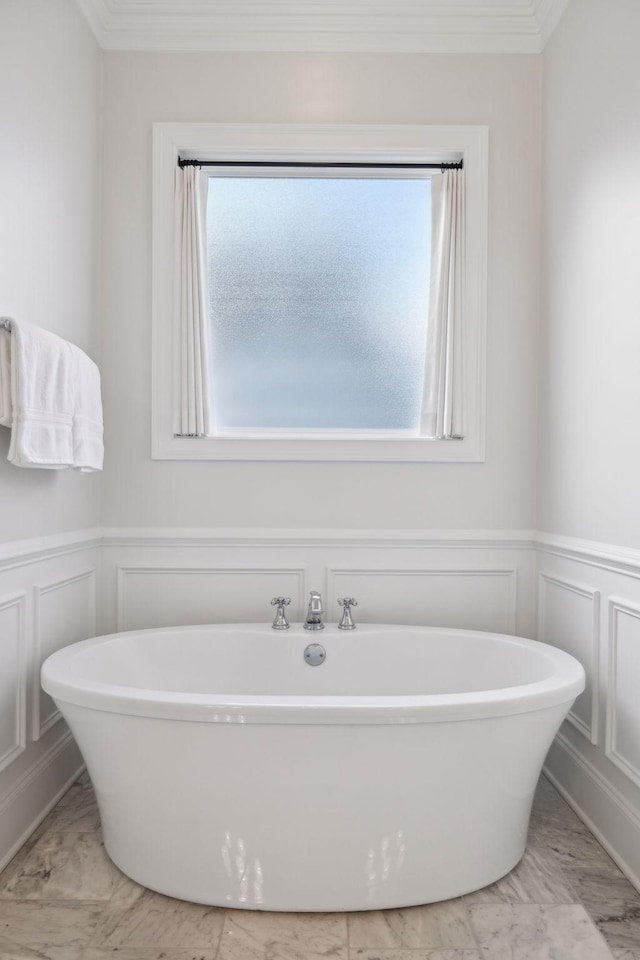 bathroom with crown molding and a washtub