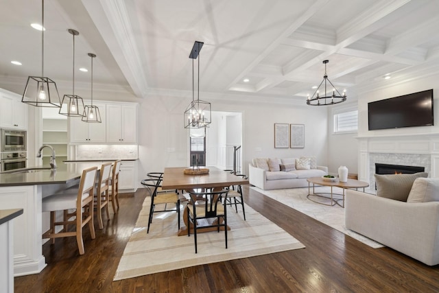 dining room with dark hardwood / wood-style floors, sink, ornamental molding, coffered ceiling, and beam ceiling