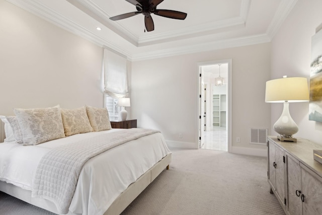 carpeted bedroom featuring crown molding, a raised ceiling, and ceiling fan