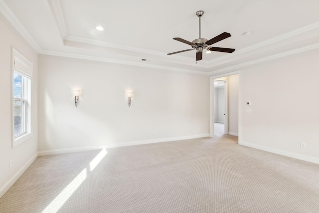 unfurnished room with crown molding, a tray ceiling, light colored carpet, and ceiling fan