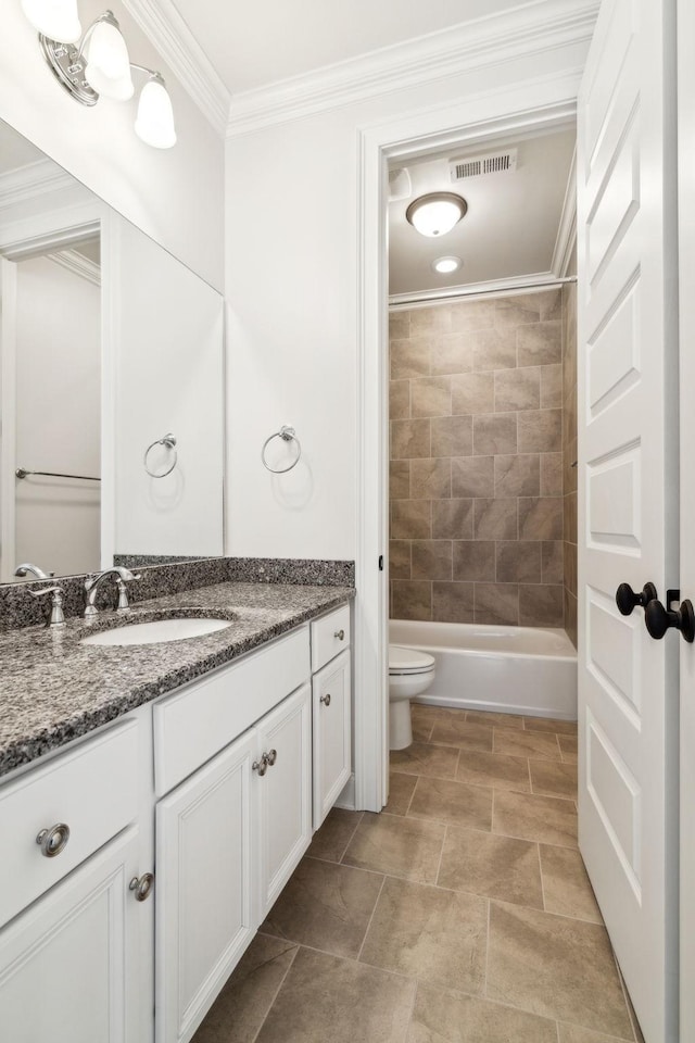 full bathroom featuring vanity, tiled shower / bath, ornamental molding, and toilet