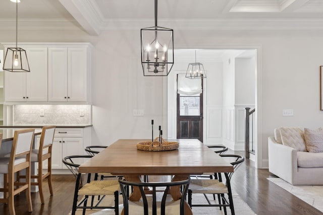 dining area featuring beam ceiling, wood-type flooring, and ornamental molding