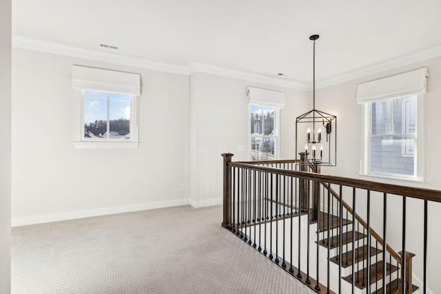 hall featuring crown molding, a chandelier, and carpet flooring