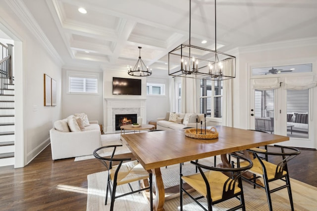 dining space with dark wood-type flooring, coffered ceiling, ornamental molding, beamed ceiling, and ceiling fan