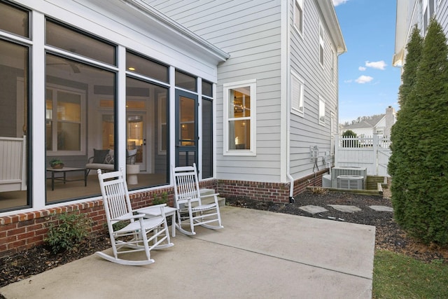 view of patio / terrace featuring central AC unit and a sunroom