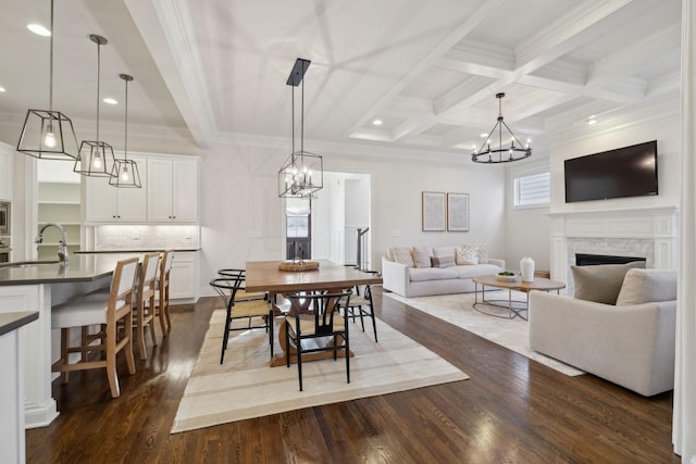 dining area with dark hardwood / wood-style flooring, sink, crown molding, and beamed ceiling